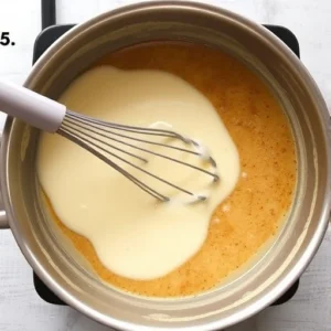 Slowly pour the warm milk mixture into the roux, whisking constantly to avoid lumps.