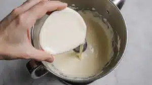 Adding softened cream cheese to creamed butter mixture for smooth cream cheese buttercream frosting