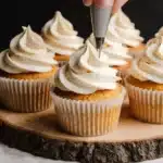 Cream cheese buttercream frosting piped with star tip creating decorative swirls on cupcakes